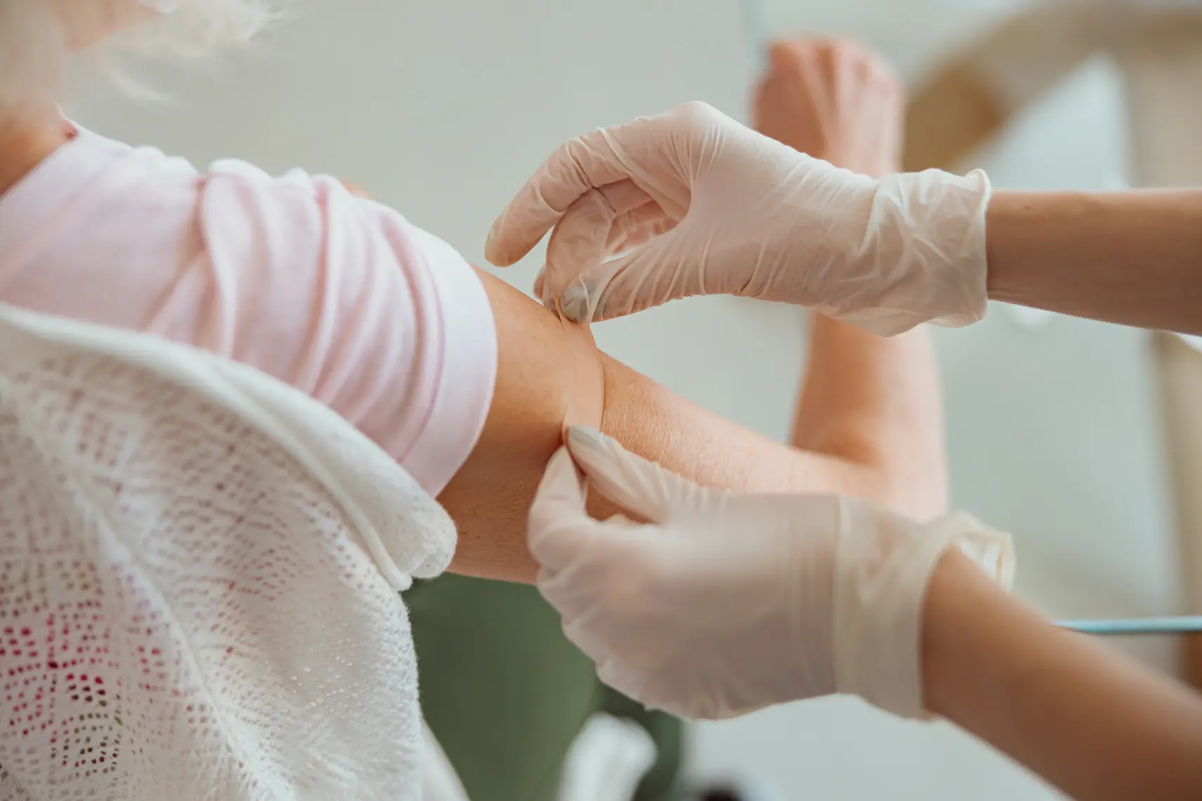 Nurse putting a plaster on a patient